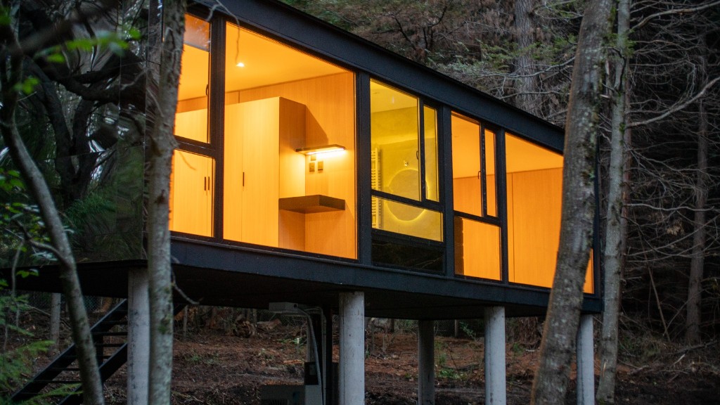 Cabaña espejada iluminada en el bosque